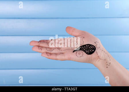 Dipinta a mano con henna su sfondo di legno Foto Stock