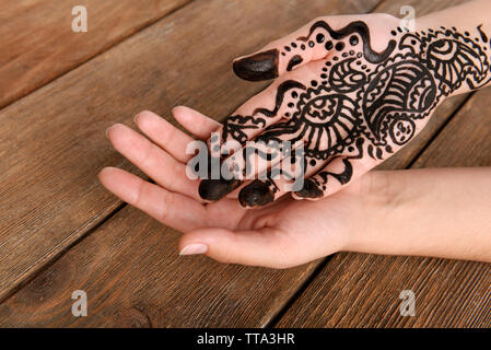 Dipinta a mano con henna su sfondo di legno Foto Stock