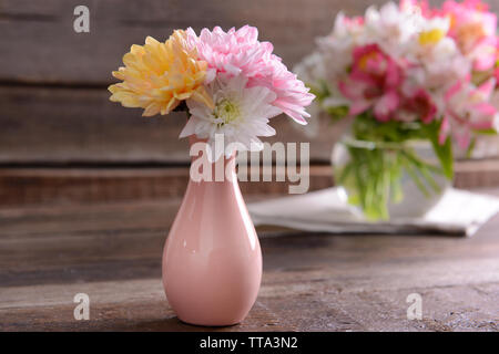 Bellissimi vasi con fiori sul tavolo vicino fino Foto Stock