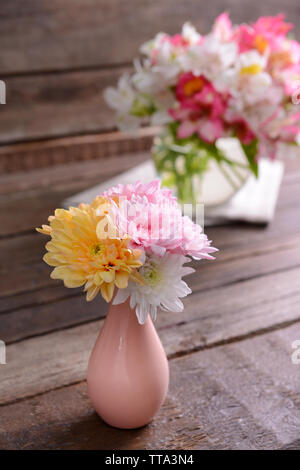 Bellissimi vasi con fiori sul tavolo vicino fino Foto Stock