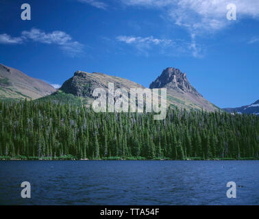 Stati Uniti d'America, Montana, il Parco Nazionale di Glacier, vista attraverso due Medicine Lake verso la foresta di conifere e picchi. Foto Stock