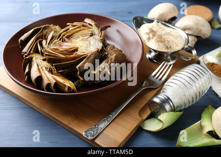 Carciofi Arrosto sulla piastra, il colore di sfondo di legno Foto Stock