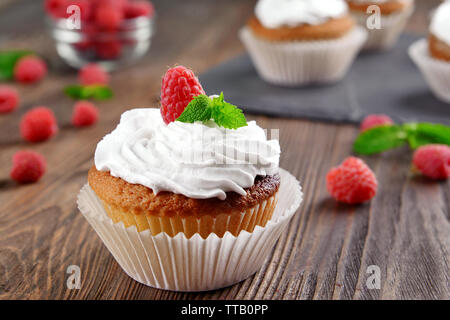 Deliziosa tortina con frutti di bosco e menta fresca sul tavolo di legno vicino fino Foto Stock