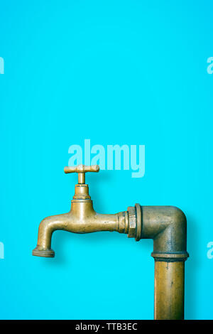Dettaglio di una acqua di rubinetto in ottone isolato sul colore di sfondo a tinta unita - immagine con spazio di copia Foto Stock