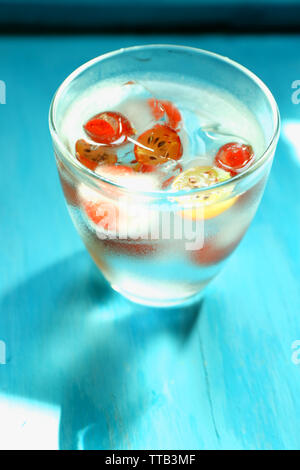 Vetro a freddo estivo rinfrescante drink con bacche e cubetti di ghiaccio sul tavolo vicino fino Foto Stock