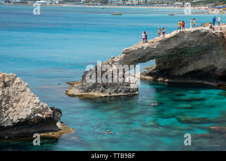 Agia Napa, , Cipro, 29 Aprile 2019: persone in piedi sopra le grotte di mare sul famoso ponte di amanti, vicino Ayia nuca, Cape Greco area in Cipro Foto Stock