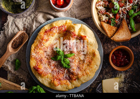 Semplice e delizioso cibo di strada, fritte, conditi con formaggio, ketchup e aglio Foto Stock