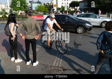 Istanbul, Turchia - 12 Giugno 2019: persone in attesa sul semaforo Kadikoy, Istanbul. Un uomo di mezza età sulla sua moto sta cercando di passare. Foto Stock