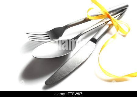 Posate legate con nastro su sfondo chiaro Foto Stock