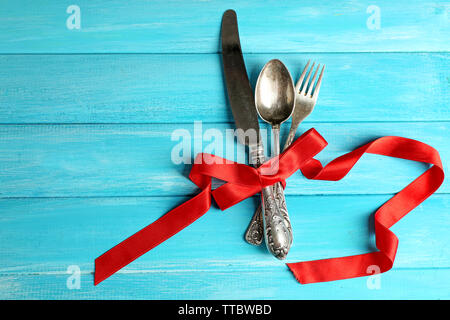 Posate legate con nastro su sfondo di legno Foto Stock