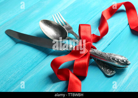 Posate legate con nastro su sfondo di legno Foto Stock