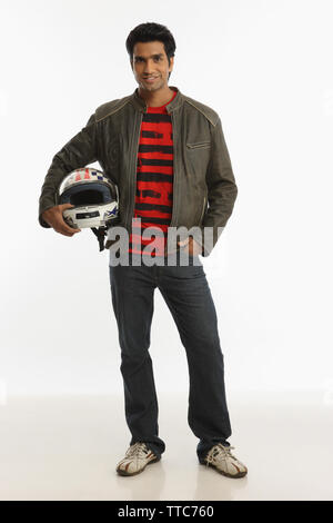 Biker holding a helmet under the arm and smiling Stock Photo