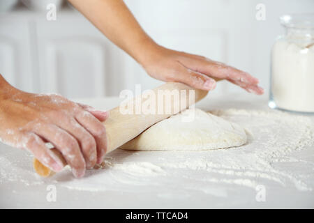 Rendendo la pasta per la torta di mele da mani femminili in cucina Foto Stock