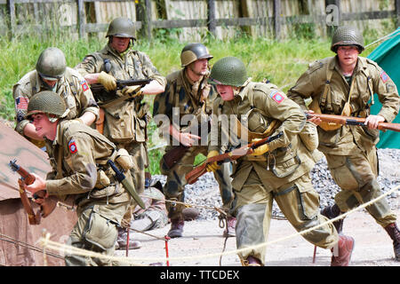 Sei Reenactors vestiti come soldati dell'esercito statunitense ottantaduesima Airborne "tutti Americani" in esecuzione Foto Stock