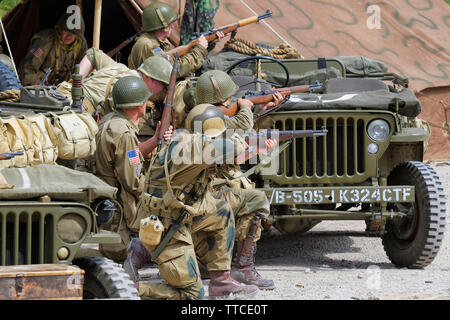 Sei Reenactors vestiti come soldati dell'esercito statunitense ottantaduesima Airborne "tutti Americani" sparando Riffles Foto Stock