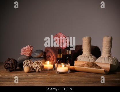 Bellissima spa impostato sul tavolo di legno contro uno sfondo grigio Foto Stock
