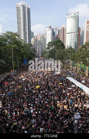 Hong Kong, Cina. Il 16 giugno 2019. I dimostranti prendere per le strade vestita di nero e il trasporto di fiori bianchi per esprimere la rabbia continua oltre la manipolazione della legge in materia di estradizione di accompagnamento e la violenza. Credito: Danny Tsai/Alamy Live News Foto Stock