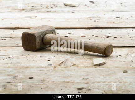 Martello forfettaria in appoggio su impalcature in legno tavole su un edificio / sito in costruzione. Copia di potenziale spazio al di sopra e al di sotto di un martello. Foto Stock