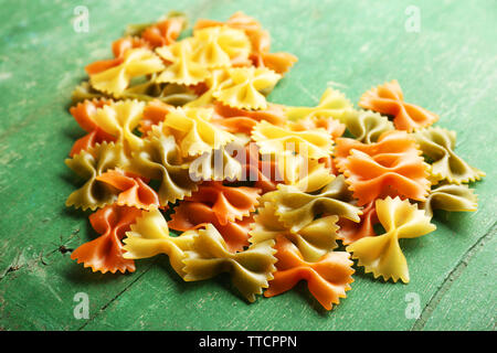 Cuore di pasta a forma di prua sul vecchio sfondo di legno Foto Stock