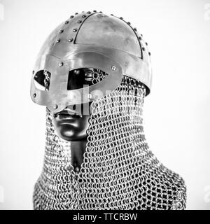Metallo, Viking casco con la catena posta in un manichino nero su sfondo bianco. i vestiti per la guerra viking Foto Stock