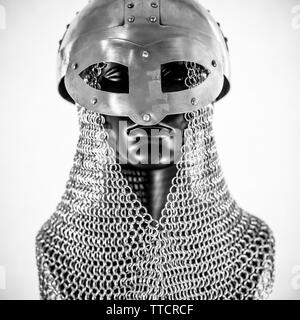 Metallo, Viking casco con la catena posta in un manichino nero su sfondo bianco. i vestiti per la guerra viking Foto Stock