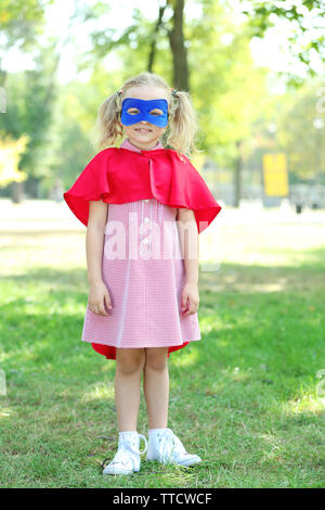 Il supereroe bambina gioca al parco Foto Stock