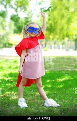 Il supereroe bambina gioca al parco Foto Stock