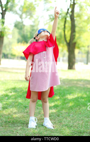 Il supereroe bambina gioca al parco Foto Stock