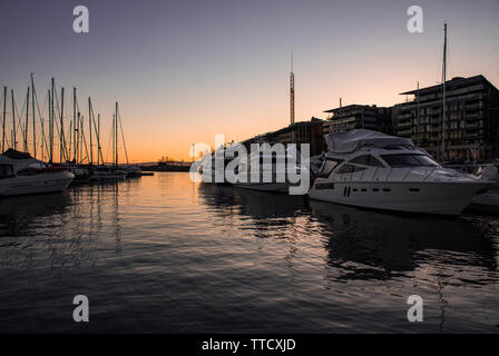 Yachts nel tramonto vicino Aker Brygge shopping center di Aker Brygge Marina, Oslo, Norvegia Foto Stock