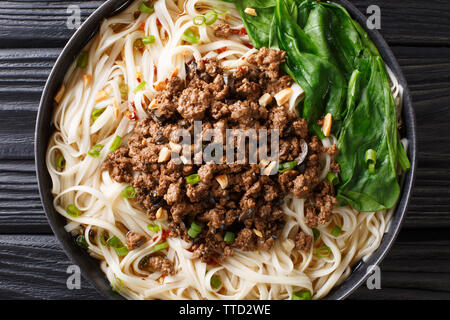 Dan Dan Noodles - saporito e Sichuan piccante tagliatelle servita con la carne di suolo closeup sulla piastra della tavola. parte superiore orizzontale vista da sopra Foto Stock