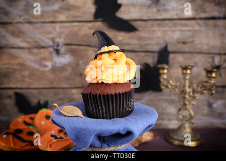 Tortina di Halloween e biscotti sul tavolo sulla parete in legno sfondo Foto Stock