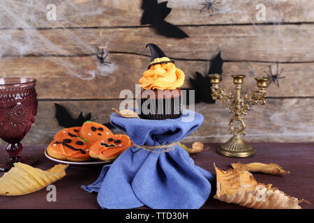 Tortina di Halloween e biscotti sul tavolo sulla parete in legno sfondo Foto Stock