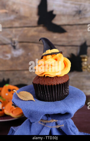 Tortina di Halloween e biscotti sul tavolo sulla parete in legno sfondo Foto Stock