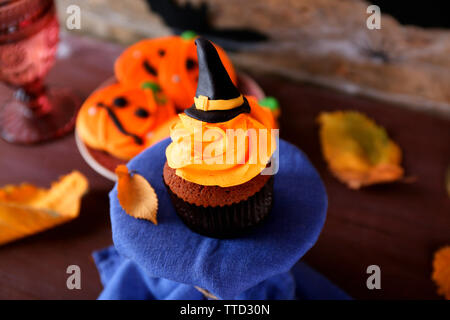 Tortina di Halloween e biscotti sul tavolo sulla parete in legno sfondo Foto Stock