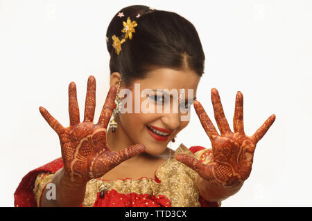 Portrait of an Indian bride showing palms decorated with mehendi Stock Photo