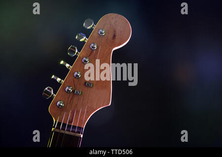 La parte di chitarra elettrica, su scuro dello sfondo illuminato Foto Stock