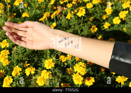 Femmina con mano tattoo di fiori di colore giallo Foto Stock