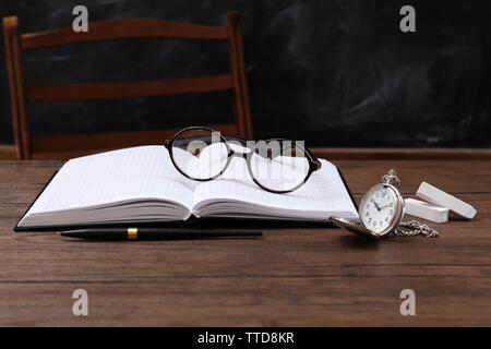 Aperto il notebook con occhiali e orologio sul tavolo di legno Foto Stock