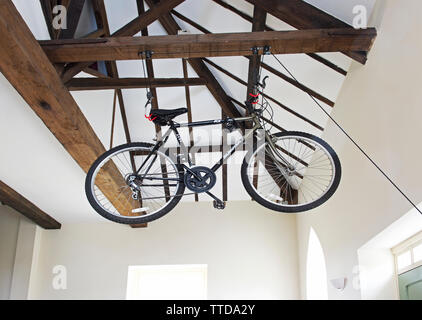 Mens bicicletta essendo memorizzato nei puntoni di una casa Foto Stock