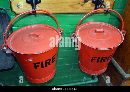 Vintage fire bucket. La Greater Manchester Servizio Antincendio Museum, in Rochdale, Regno Unito, è la pianificazione per avviare i lavori di costruzione alla sua nuova posizione, l'adiacente ex Maclure Road stazione dei vigili del fuoco, entro la fine di quest'anno .L'edificio sarà completamente restaurato alla sua 1930 condizione entro la fine del 2020. Lo spostamento di grandi locali significa che full-sized motori Fire può essere visualizzato, accanto a molte affascinanti elementi storici di attrezzatura antincendio. Foto Stock