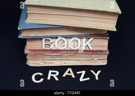 Una pila di 4 vecchi libri con uno slogan in caratteri di legno Foto Stock
