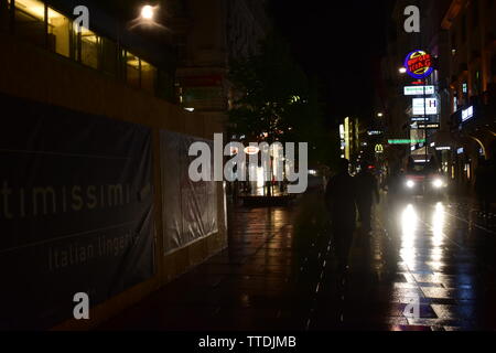 Foto di Karntner Strasse con la gente che camminava situato nel centro della città di Vienna durante una notte piovosa Foto Stock