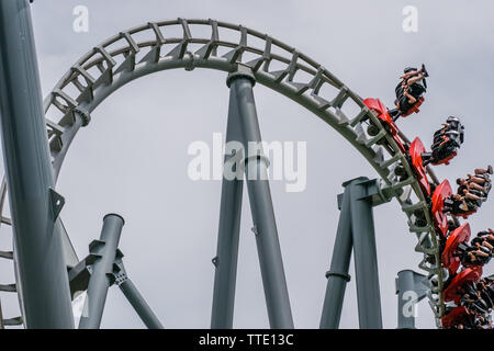 Roller Coaster ride dentro il parco di divertimenti su un nuvoloso giorno Foto Stock