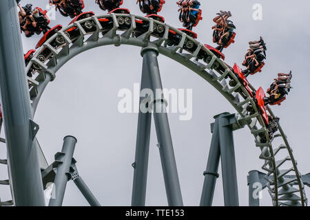 Roller Coaster ride dentro il parco di divertimenti su un nuvoloso giorno Foto Stock