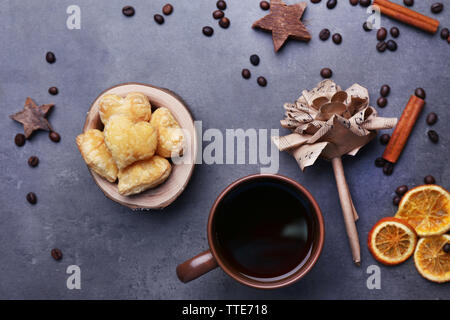 A forma di cuore biscotti nella ciotola con le spezie secche su sfondo grigio scuro Foto Stock