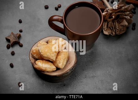 A forma di cuore biscotti nella ciotola con le spezie secche su sfondo grigio scuro Foto Stock