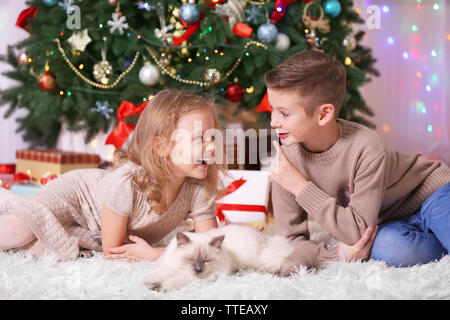 I bambini e il sonno gatto in decorata sala di Natale Foto Stock