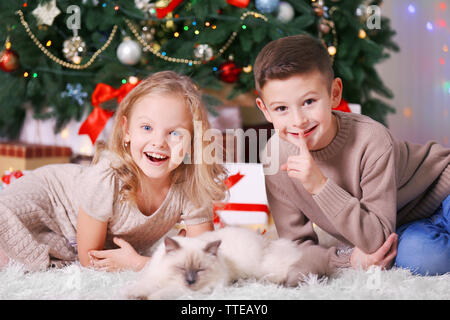 I bambini e il sonno gatto in decorata sala di Natale Foto Stock