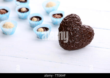 Cuore di cioccolato e caramelle su uno sfondo luminoso Foto Stock
