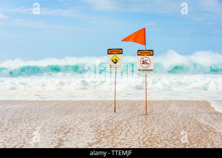Cartelli di avvertimento che indica assenza di nuoto ammessi a causa delle enormi ondate e pericoloso shorebreak vicino il Banzai Pipeline sulla North Shore di Oahu, Hawaii. Foto Stock